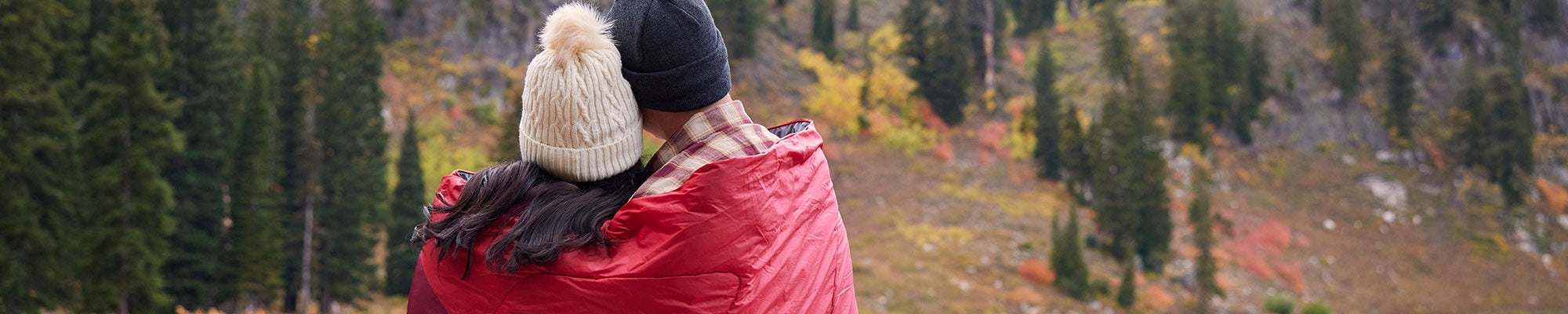 A man and a woman snuggle together in their TETON Sports Outdoor Camp Blanket
