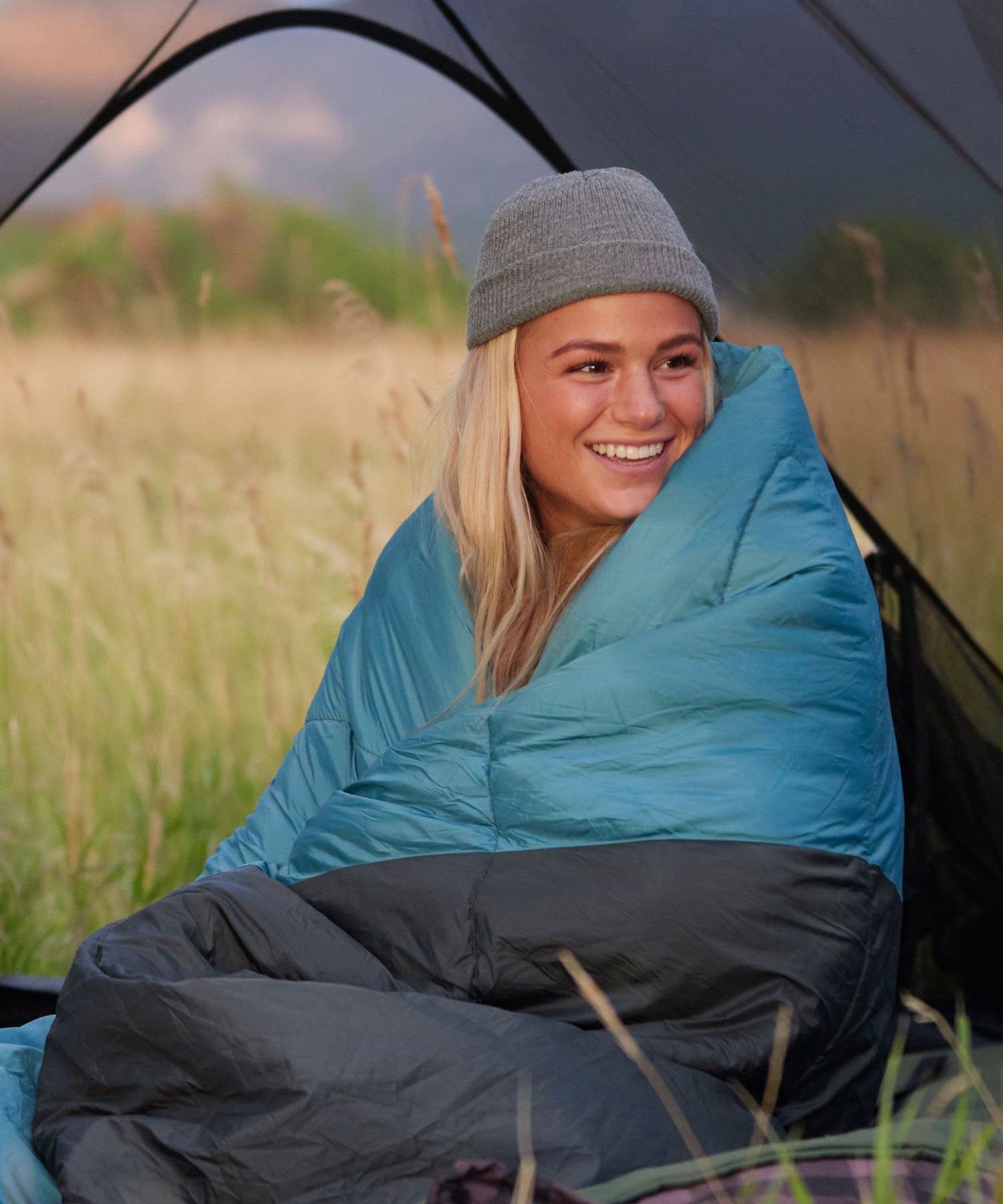 A woman snuggled up in her TETON Sports outdoor camp blanket.
