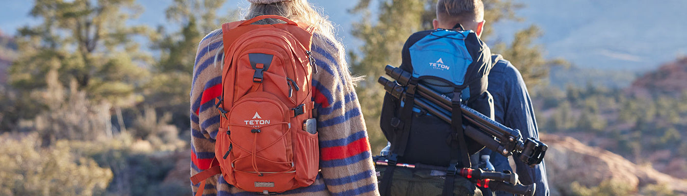 A woman wearing a TETON Sports pack hikes in the foothills.