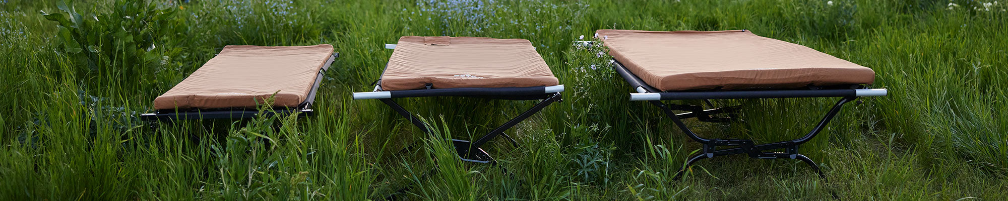 TETON Sports camp cots with canvas camp pads are set up showcasing three different sizes.