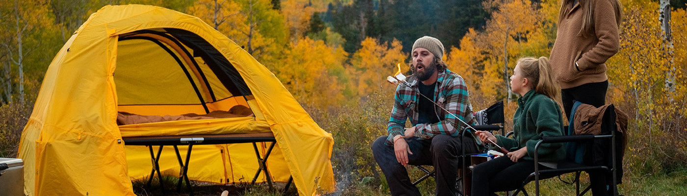 A family camps together in an autumn forest using TETON Sports tents & camping gear.