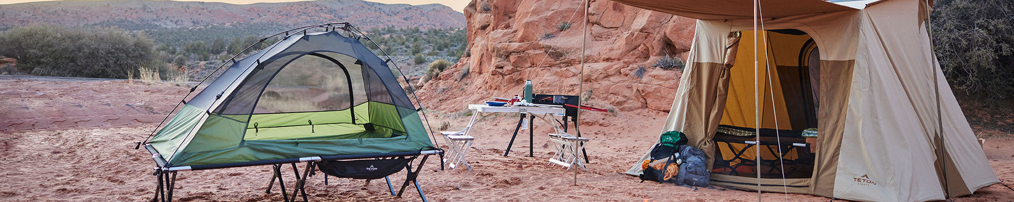 A vista tent and Mesa canvas tent are pictured in a sandy campsite.