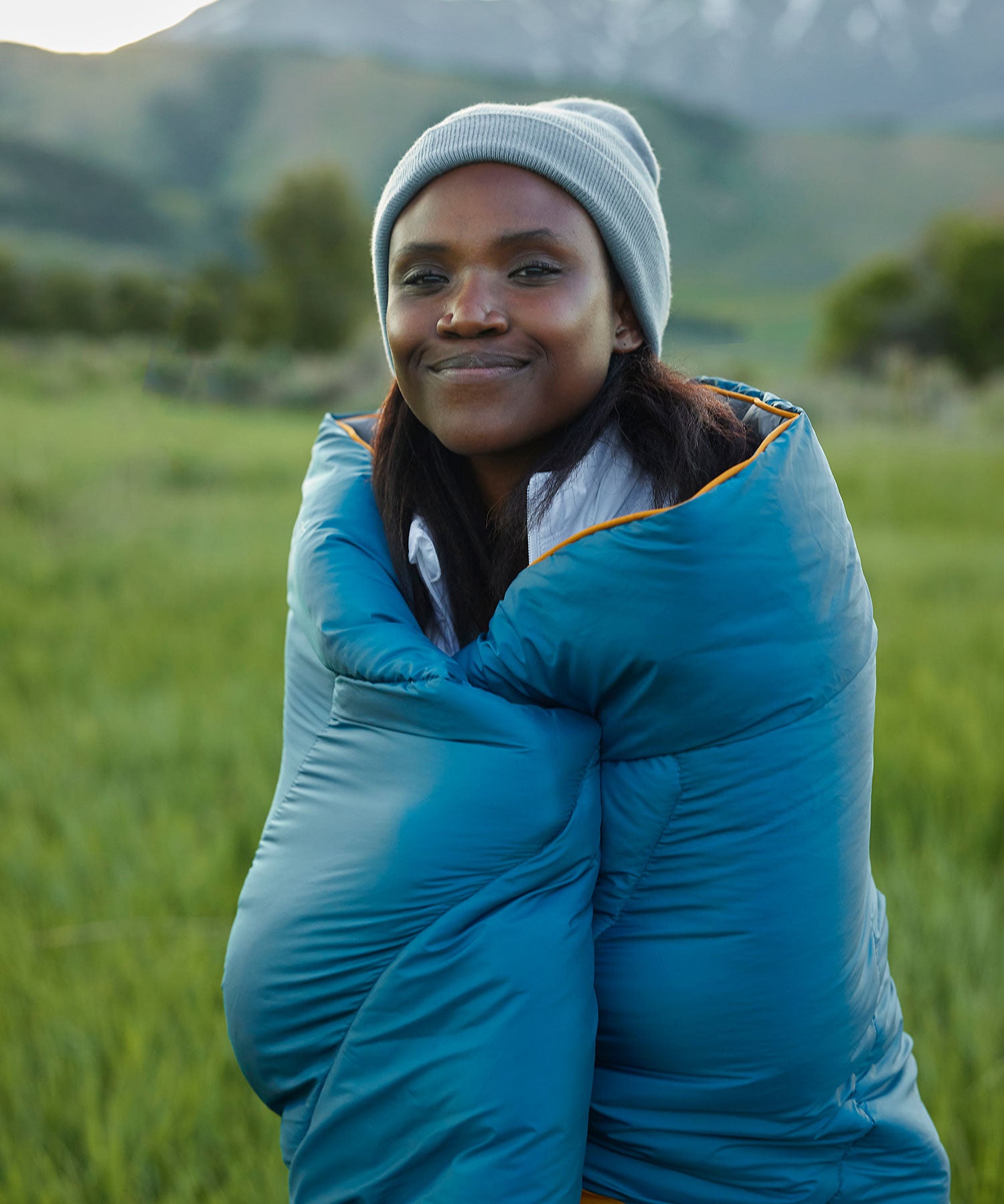 A woman snuggled up in her TETON Sports outdoor and camp blanket.
