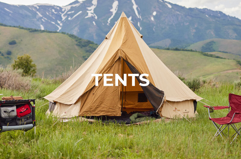 A campsite setup with the TETON Sports Sierra canvas tent and mountainous scenery in the background.