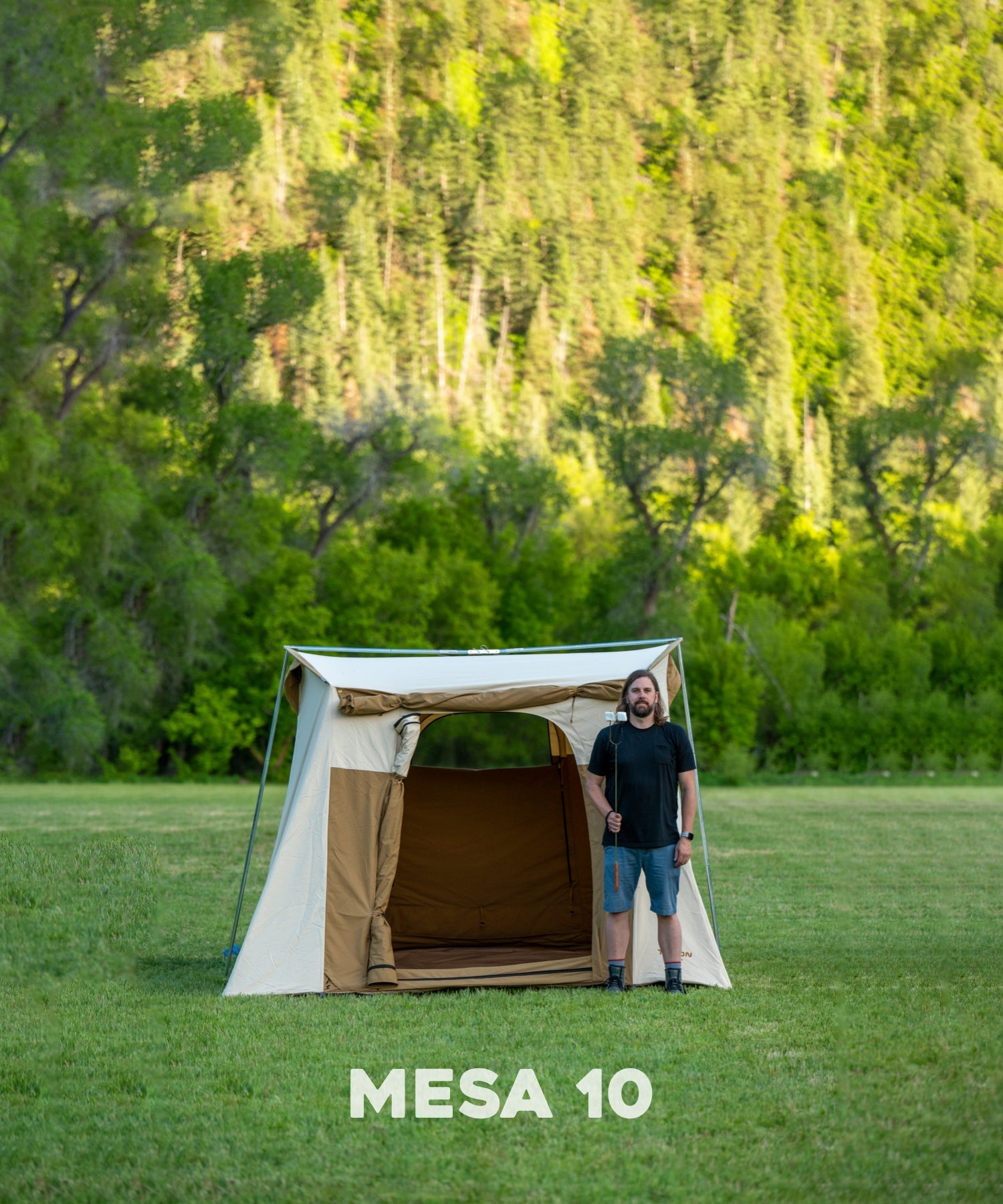 The TETON Sports Mesa 10' Canvas Tent: Image shows a man standing in front of the tent with a marshmallow stick to show comparative size.
