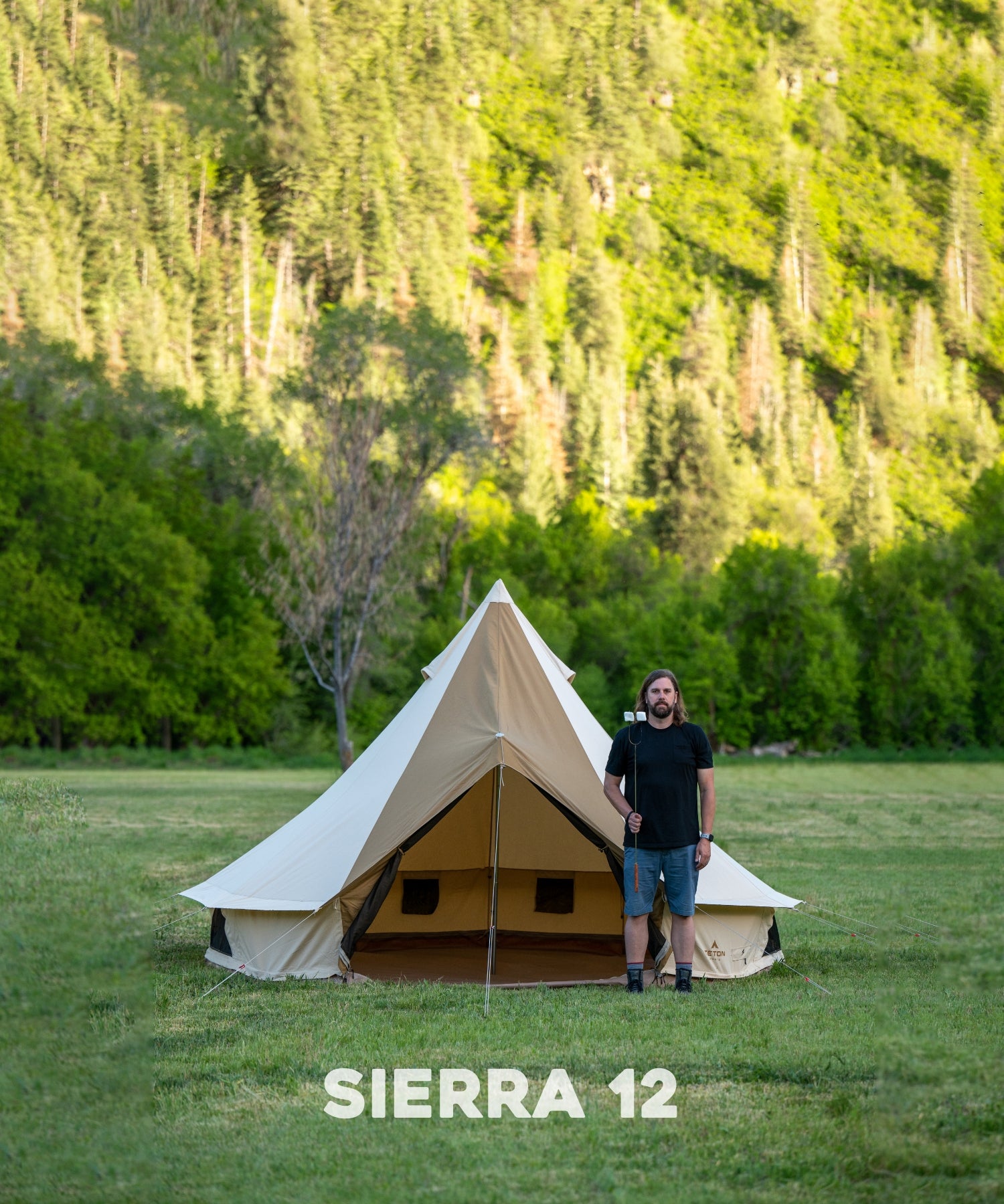 The TETON Sports Sierra 12' Canvas Tent: Image shows a man standing in front of the tent with a marshmallow stick to show comparative size.