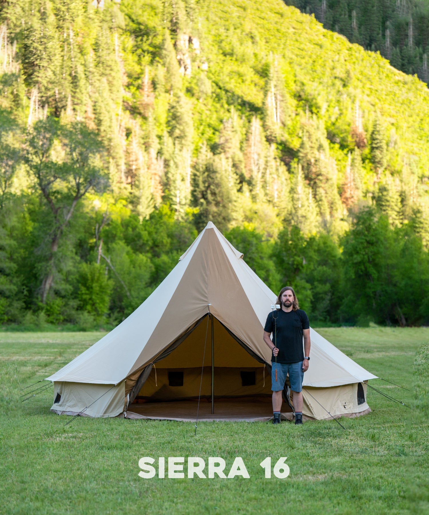 The TETON Sports Sierra 16' Canvas Tent: Image shows a man standing in front of the tent with a marshmallow stick to show comparative size.