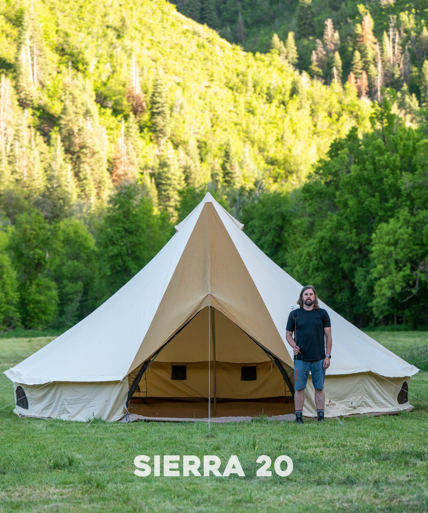 The TETON Sports Sierra 20' Canvas Tent: Image shows a man standing in front of the tent with a marshmallow stick to show comparative size.